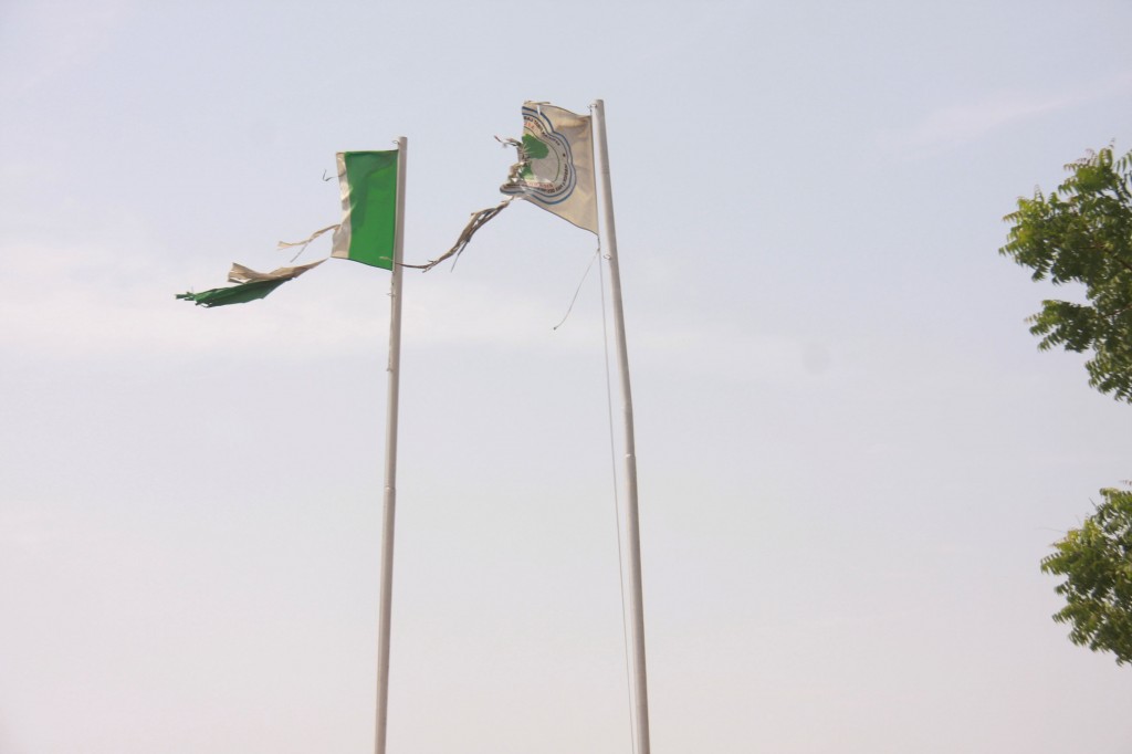 Tattered Nigerian national and African First Ladies’ Mission flags flying side by side in front of Bayelsa State House, near Federal High Court, Abuja on Monday